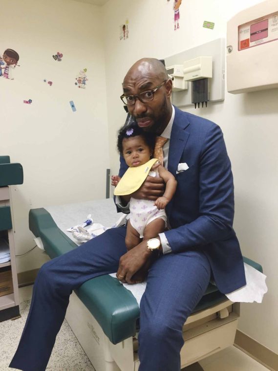 father and infant at pediatrician, both with same apprehensive expression on their faces