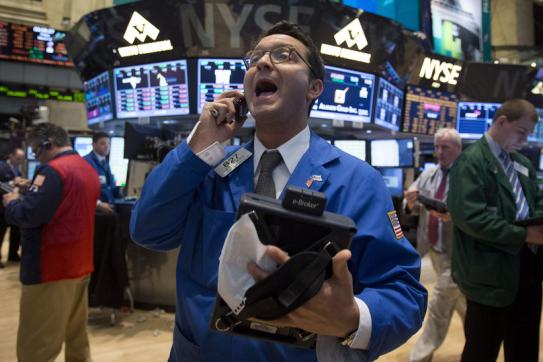 Someone yelling excitedly into their cell phone, standing on the stock exchange floor