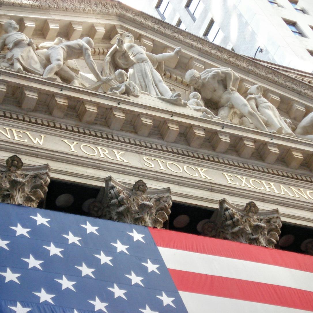 The New York Stock Exchange front with an American flag